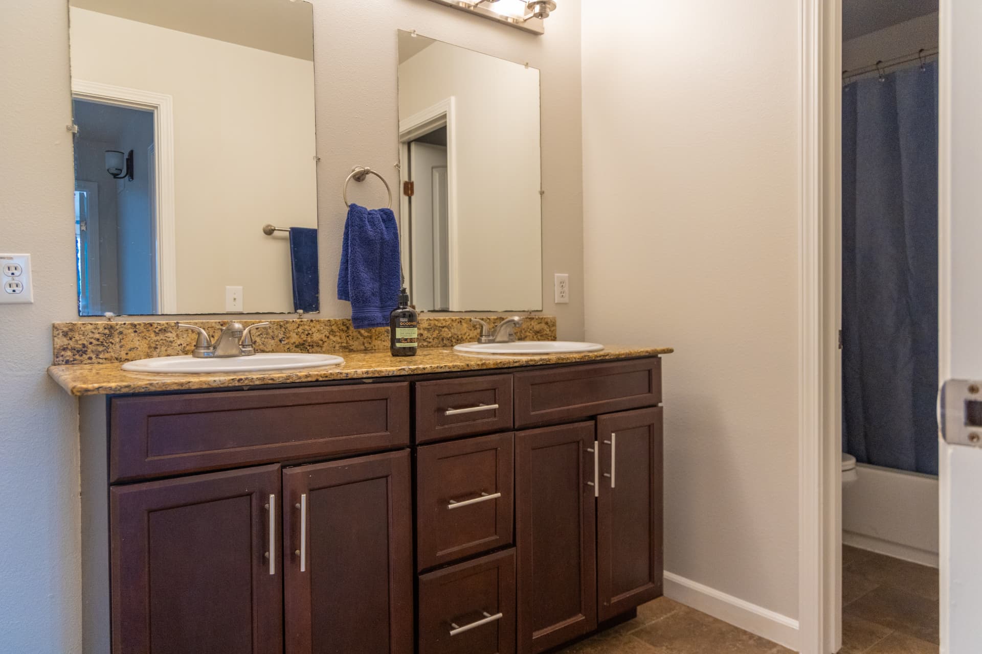 Bathroom with a double vanity, large mirrors, and shower