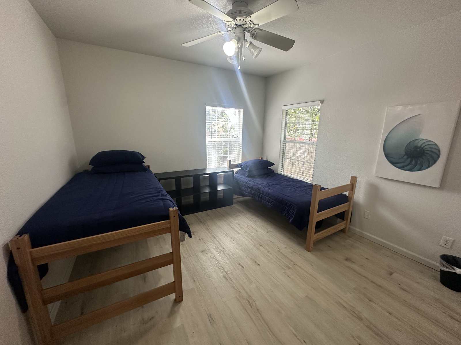 Bedroom with two twin beds, shared shelving, and windows