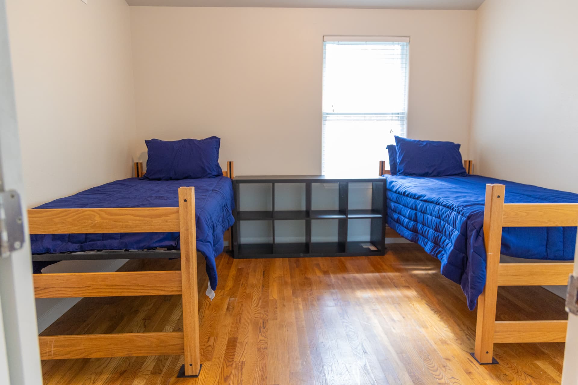 Bedroom with two twin beds and shared shelving between them