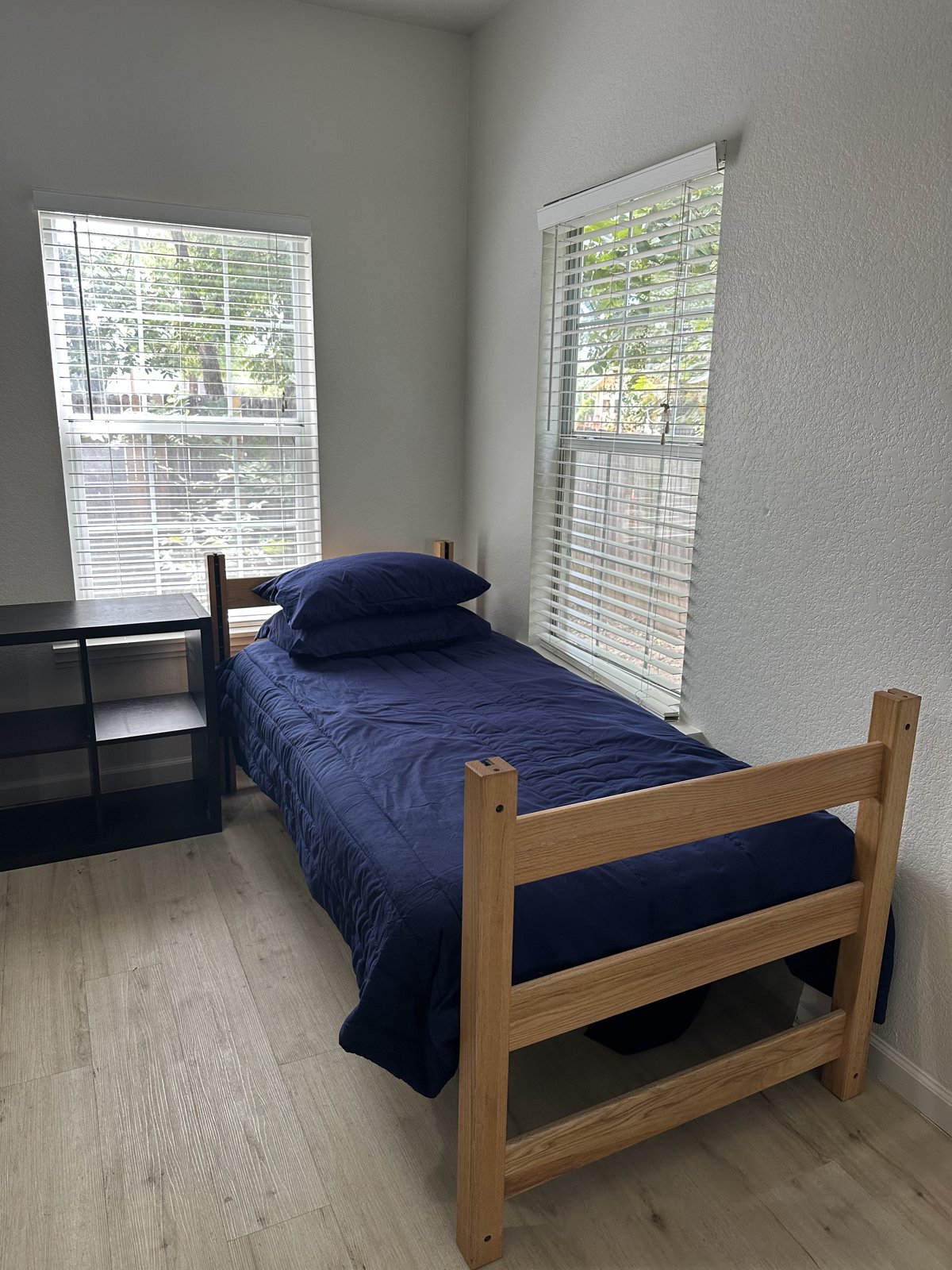 Single bedroom with a twin bed and two windows