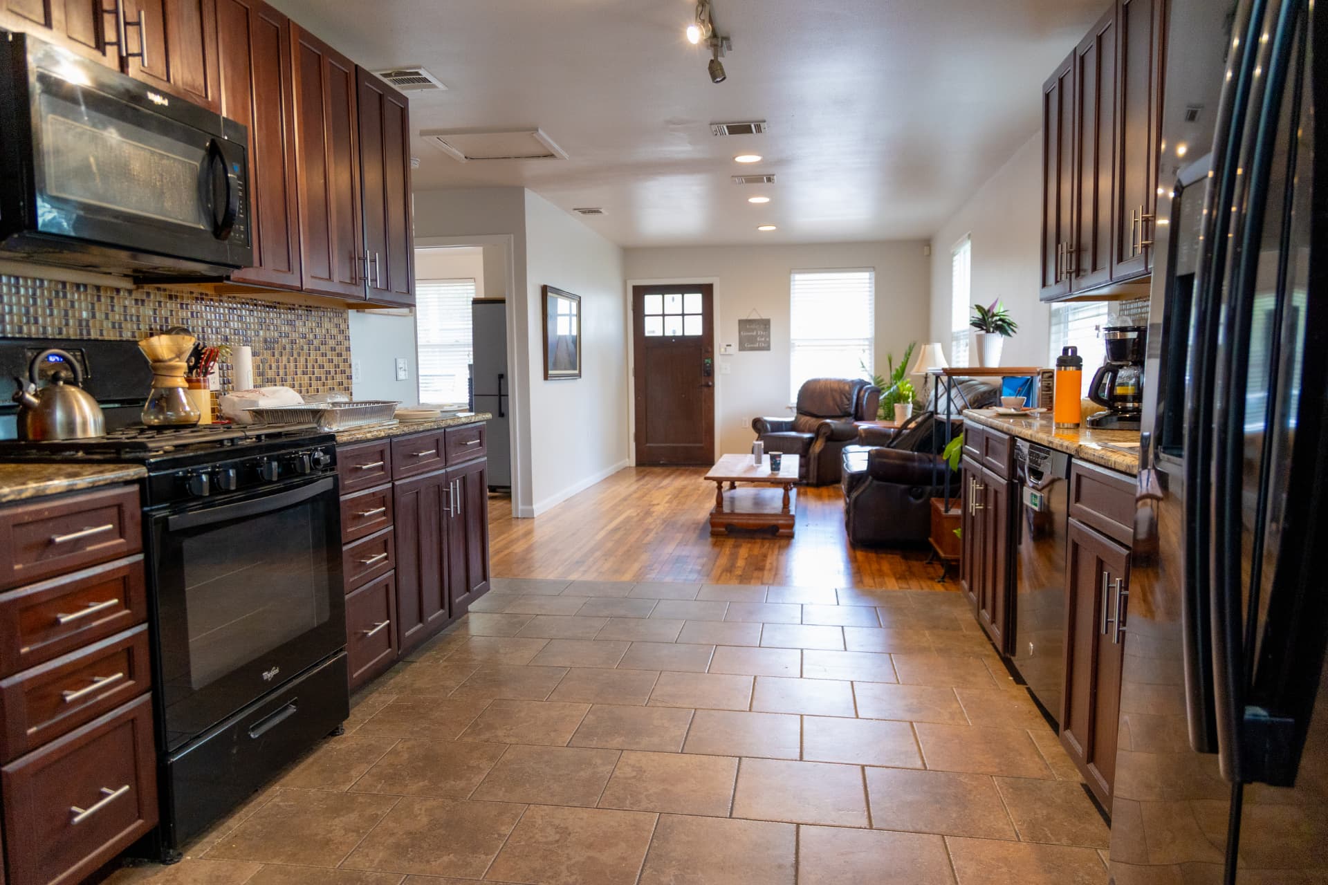 Full kitchen with gas range, stainless appliances, and tile floor