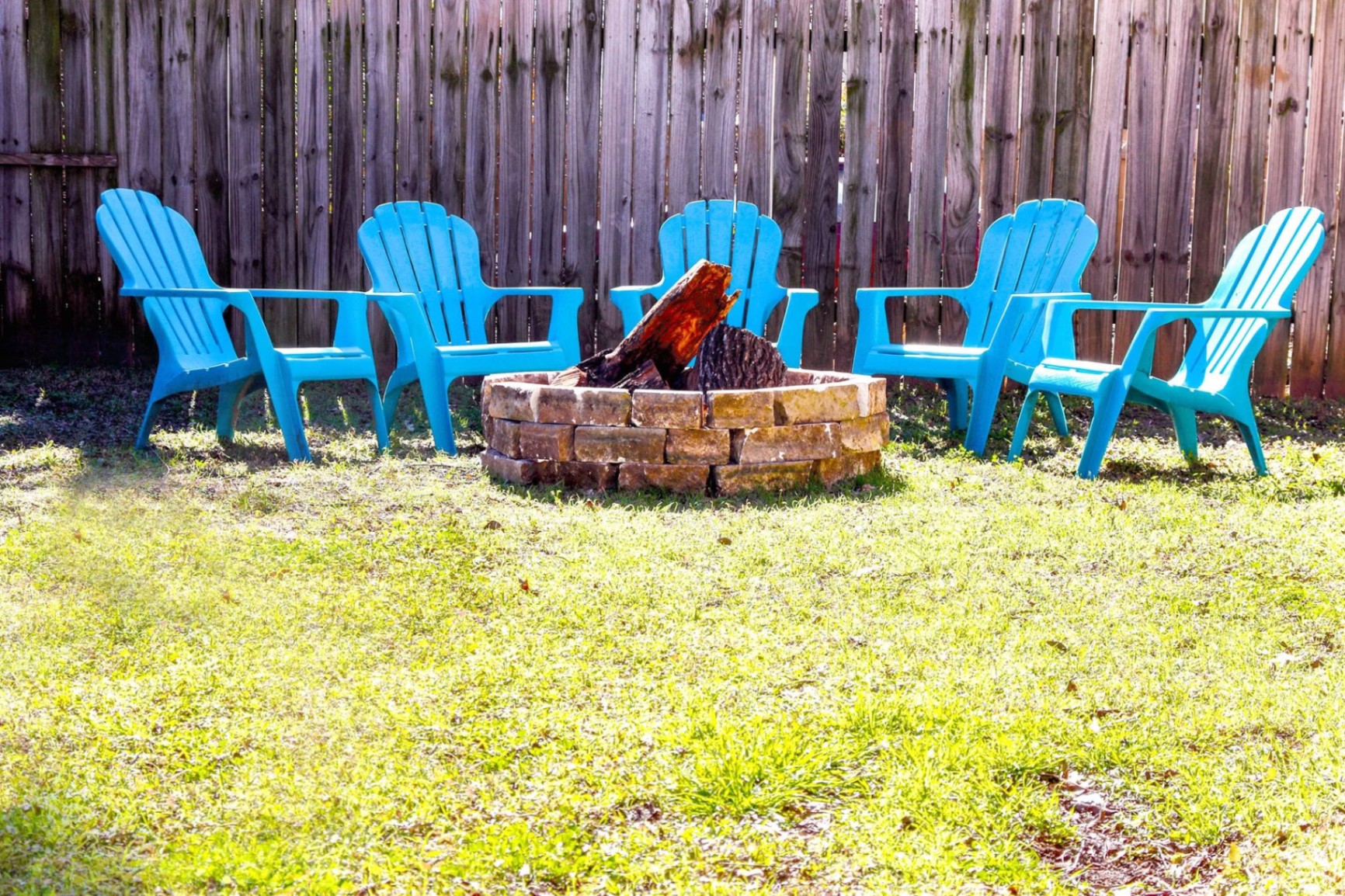 Fire pit surrounded by Adirondack chairs
