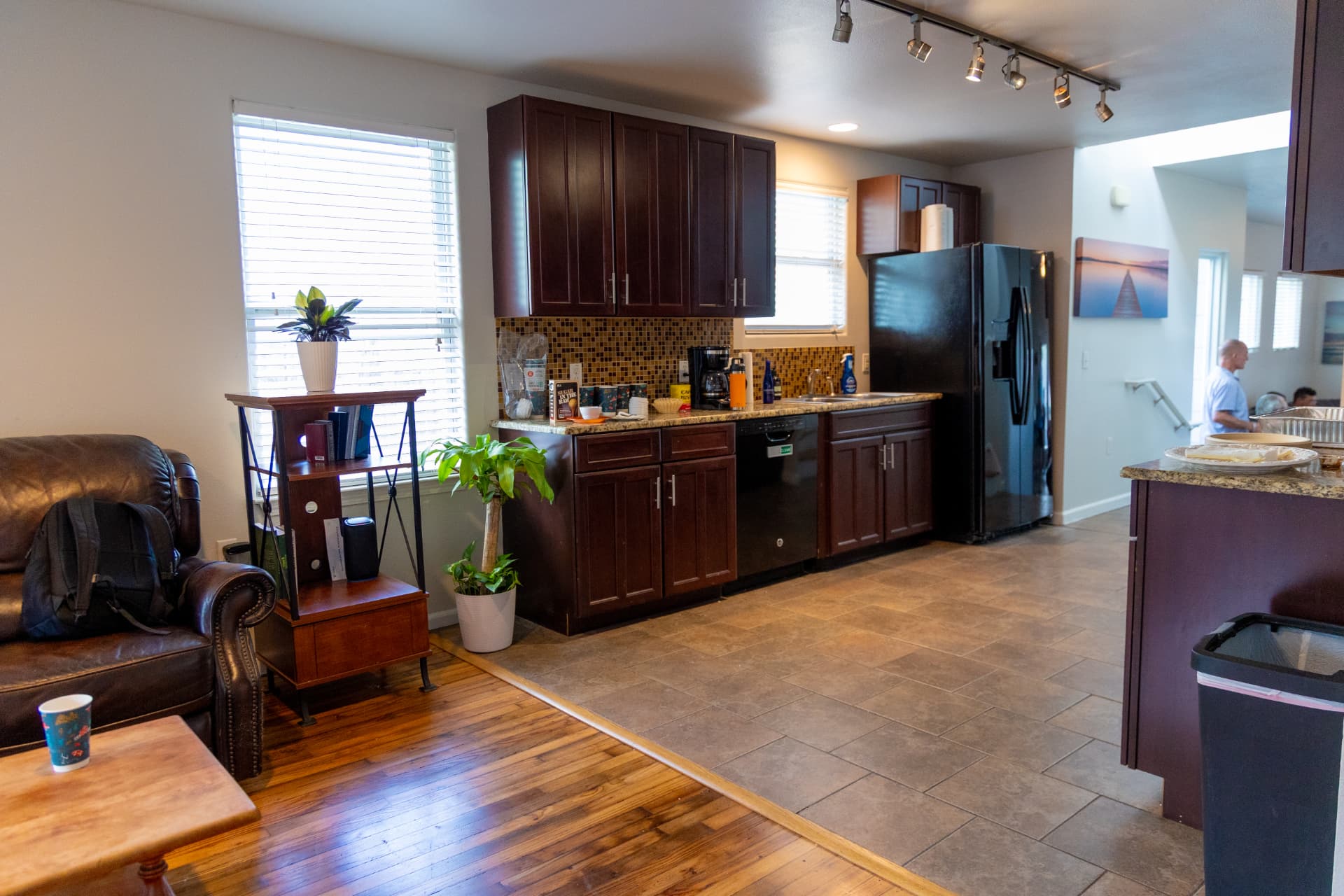 Kitchen with dark cabinetry opening onto the living room