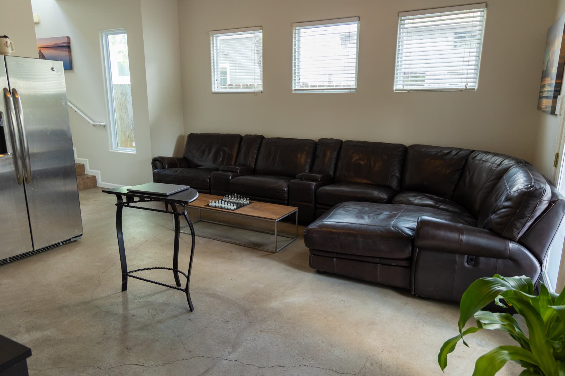 Downstairs lounge with a long leather sectional and chess set